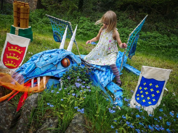 Little girl riding on a dragon made as part of the well dressing