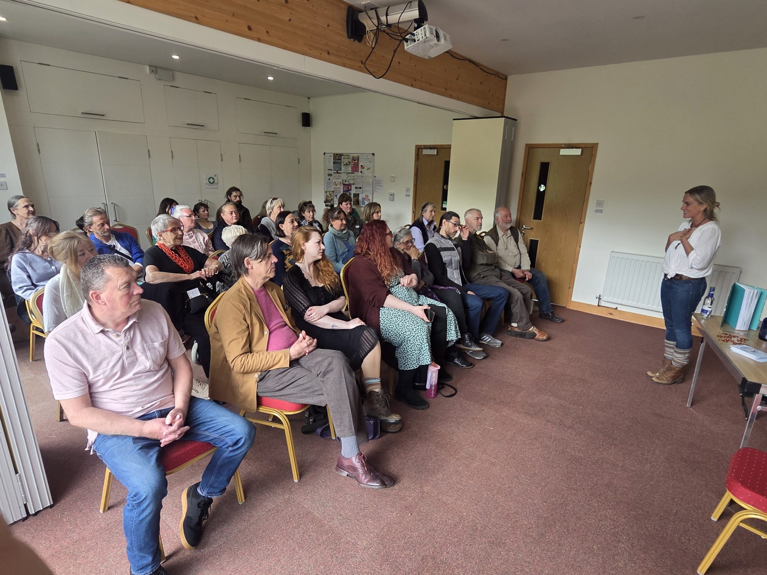 Charlotte Emily Rose presenting a passionate talk to a large audience at The Cube