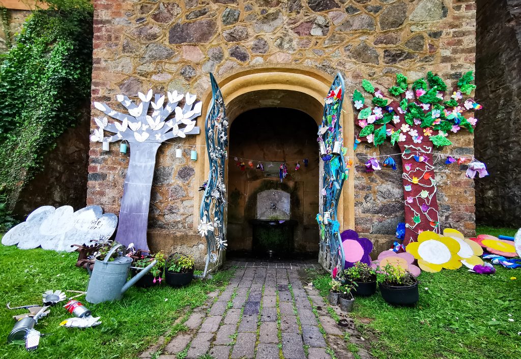 The clock tower decorated with crafted trees and flowers